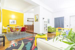 un soggiorno con pareti gialle, tavolo e sedie di da ARMIDA VIP Flat a Napoli
