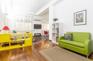 sala de estar con sofá verde y armario amarillo en da ARMIDA VIP Flat, en Nápoles