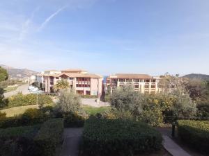 widok na budynek z krzakami i drzewami w obiekcie Cap Esterel Studio climatisé vue mer partielle w mieście Agay - Saint Raphael