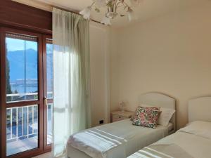 a bedroom with two beds and a window with a view at Fabula Home Rental - GiannaRosa in Lovere