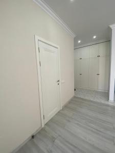 a white room with a door in the middle of it at Жк Арман двухкомнатная квартира в центре города/ Zhk Arman one-bedroom apartment in the city center in Atyraū