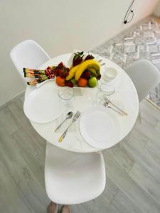 une table blanche avec une assiette de fruits sur elle dans l'établissement Жк Арман двухкомнатная квартира в центре города/ Zhk Arman one-bedroom apartment in the city center, à Atyraū