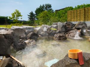 une piscine d'eau avec des rochers et une cascade dans l'établissement Ooedo Onsen Monogatari Premium Hotel Sokan, à Matsushima