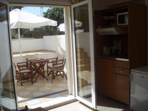 a kitchen with a table with chairs and an umbrella at Aegean Sun Hotel in Skala Rachoniou