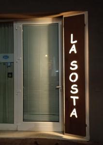 a sign on the door of a building with the wordanya at Ostello La Sosta in Contrada Anselmi