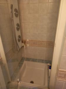 a small bathroom with a tub and a shower at le héron cendré in Lans-en-Vercors