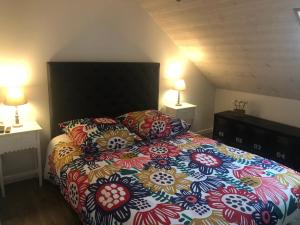ein Schlafzimmer mit einem großen Bett mit bunten Kissen in der Unterkunft Happy HOME in Cierp