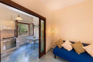ein Wohnzimmer mit einem blauen Sofa und einer Küche in der Unterkunft Maison Marianna in Sorrent