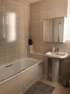 a bathroom with a tub and a sink and a bath tub at Great House + air conditioning + free car parking in Manchester