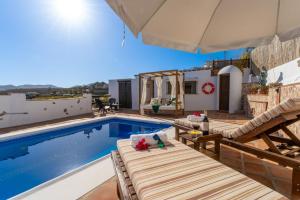 een villa met een zwembad en een huis bij Casa Herrero in Nerja