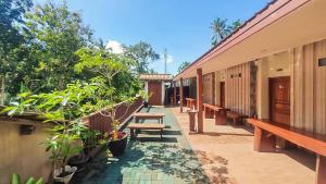 a corridor of a building with benches and plants at RedDoorz Syariah at Banyu Asem Banyuwangi in Banyuwangi +19 photos