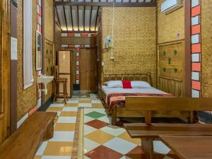 um quarto com uma cama e um banco num quarto em RedDoorz Syariah at Banyu Asem Banyuwangi em Banyuwangi