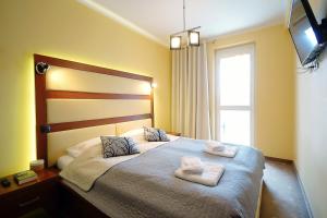 Posteľ alebo postele v izbe v ubytovaní OnHoliday Apartamenty w Hotelu przy ul Kościuszki 16