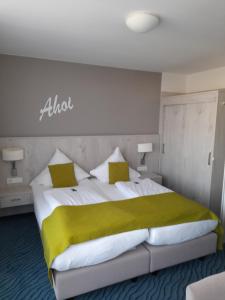 um quarto com uma cama grande e um cobertor amarelo em Inselhotel Rote Erde em Borkum