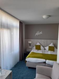 Habitación de hotel con cama y sofá en Inselhotel Rote Erde en Borkum