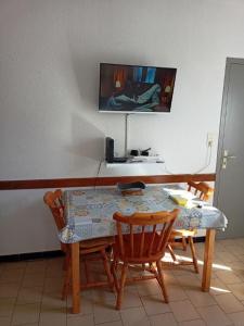 a dining room table with two chairs and a television at Appartement 4 personnes Vieux-Boucau in Vieux-Boucau-les-Bains