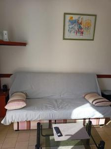 a couch sitting in a living room with a table at Appartement 4 personnes Vieux-Boucau in Vieux-Boucau-les-Bains