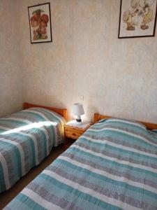 a bedroom with two beds and a lamp on a night stand at Appartement 4 personnes Vieux-Boucau in Vieux-Boucau-les-Bains