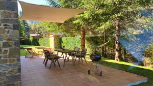 a patio with a table and chairs and a grill at Casa MARAVILLA 8 pax. Deporte y relax exclusivo! in La Molina
