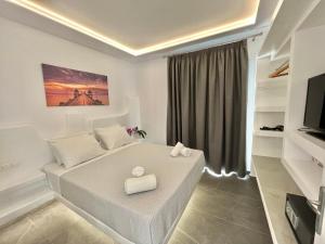 a white room with a bed and a television at Crystal Suites in Mýkonos City