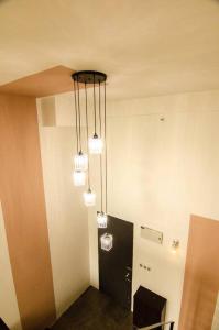 Zimmer mit 3 Lichtern, die von der Decke hängen in der Unterkunft Bathtub Soho, Forest View Empire Damansara in Petaling Jaya