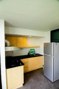 eine Küche mit einem weißen Kühlschrank und Holzschränken in der Unterkunft Bathtub Soho, Forest View Empire Damansara in Petaling Jaya