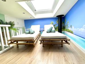 two beds in a room with a swimming pool at Wellness at Sea in Egmond aan Zee