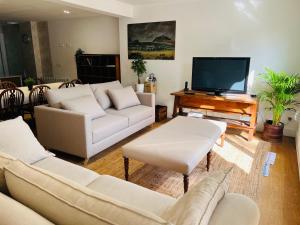 sala de estar con muebles blancos y TV de pantalla plana en Loreartean by Basque Homes, en Hondarribia