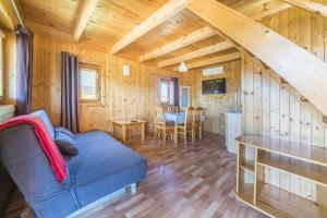een woonkamer met een blauwe bank in een houten huisje bij DRAGA AM Konkel in Jastarnia