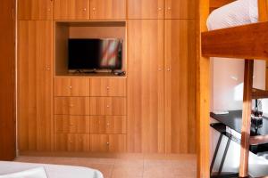 a room with wooden cabinets with a television in it at Ridomo Canyon Apartment 