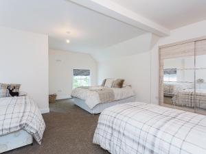 a bedroom with two beds and a window at Yokefleet Cottage in Eastrington