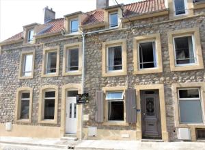 a stone building with a door on a street at Mer&Campagne Wimille in Wimille