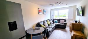 sala de estar con sofá y mesa en 2 Rosemullion en Perranporth