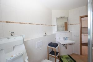 ein weißes Badezimmer mit einem Waschbecken und einem Spiegel in der Unterkunft Ferienwohnungen-Am Kurpark in Bad Saarow