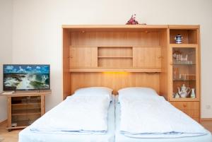 ドゥネンにあるHaus Hanseatic, Wohnung 105のベッド2台と薄型テレビ付きのベッドルーム