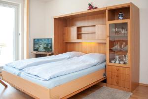 ドゥネンにあるHaus Hanseatic, Wohnung 105の木製キャビネット付きの部屋のベッド1台分です。