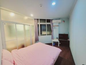 a bedroom with a white bed and a window at Easy B&B in Jiufen