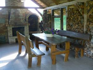 a wooden table and two chairs with a fireplace at Staszkowa Zagroda nad Rospudą in Jabłońskie