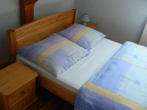 a bed with a wooden headboard and two pillows at Staszkowa Zagroda nad Rospudą in Jabłońskie