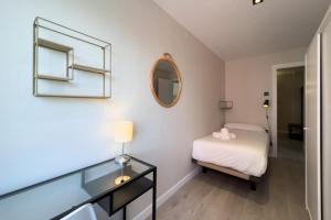 a small bedroom with a bed and a mirror at Confy 3 bedroom apartment in Sant Andreu in Barcelona