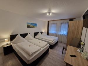 um quarto de hotel com duas camas e uma mesa em Das SP Hotel em Fürth