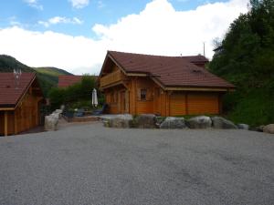 Una casa con un camino de entrada de grava en frente de ella en Les Noisettes, en La Bresse