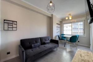 uma sala de estar com um sofá e uma mesa em Confy 3 bedroom apartment in Sant Andreu em Barcelona