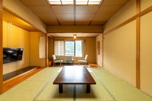Ooedo Onsen Monogatari Kounkaku في Osaki: غرفة معيشة مع طاولة وتلفزيون