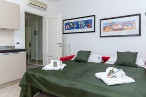 una camera con un letto verde con asciugamani di L'Ulivo di Cecilia ad Alassio