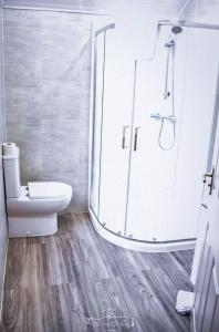 ein Badezimmer mit Toilette und Glasdusche in der Unterkunft Dobbins Inn in Carrickfergus