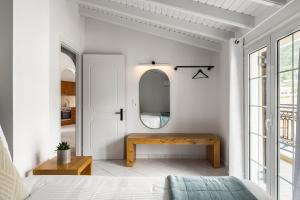 a bedroom with a wooden table and a mirror at The Seaview Corner Apartments by Konnect, Ipsos Corfu in Ýpsos