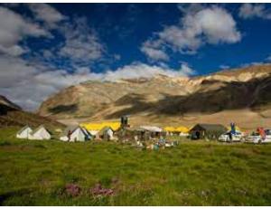 a group of tents in a field with a mountain at Dorje Camps Sarchu, Manali in Manāli