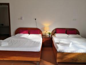 two beds sitting next to each other in a room at Sling N Stone Vacation Homes, Mt Kinabalu in Kundasang