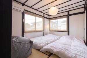 a bedroom with a white bed and two windows at FTH maroon 4min to station in Azagawa